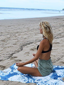 A woman meditating on a beach